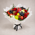Mix fruits and flowers bouquet with apples, grapes, strawberries, roses and greenery wrapped in white tissue with a black satin ribbon bow
