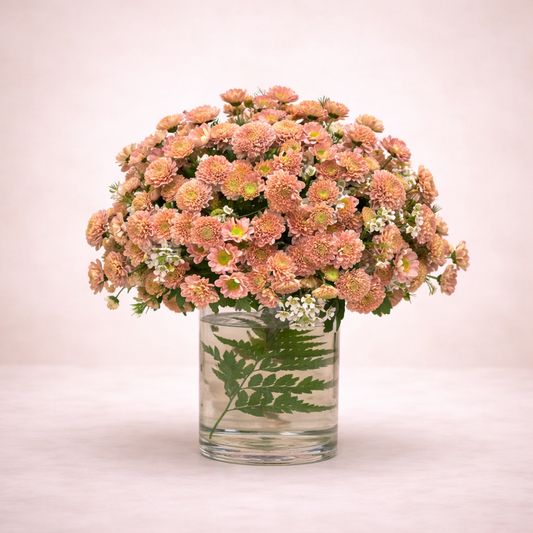 Bouquet of pink flowers in a clear vase on a light pink background