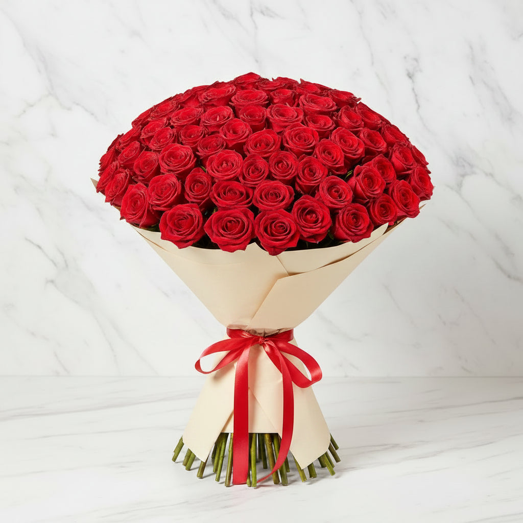 Bouquet of red roses wrapped in beige paper with a red ribbon.