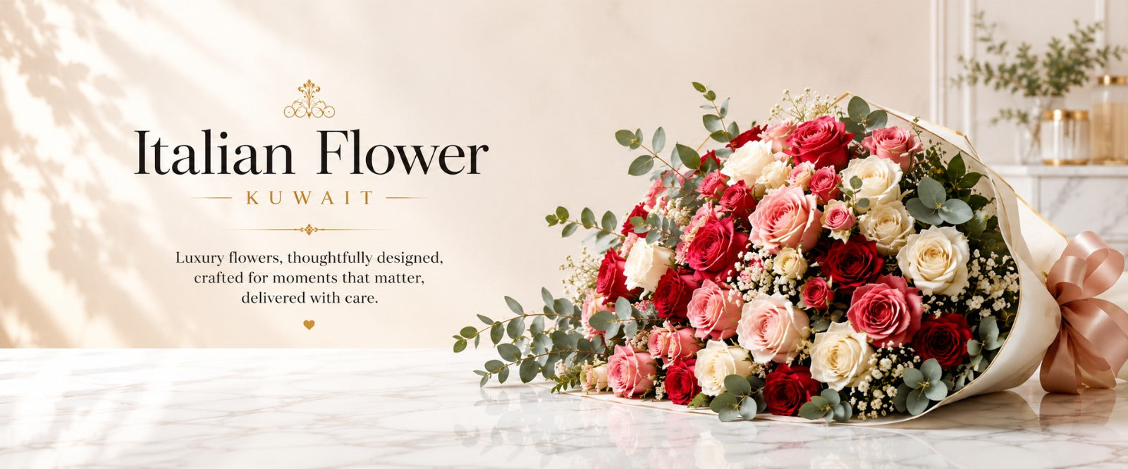A bouquet of Italian Flower Kuwait luxury flowers, featuring red, pink, and cream roses with green eucalyptus, displayed on a marble surface next to the brand logo on a beige background.